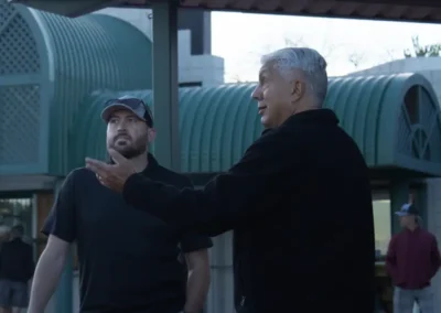 Two golfers talking next to the golf clubhouse.