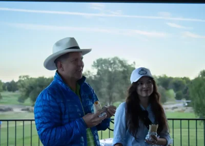 Two golf tournament participants enjoying burritos next to the golf course.