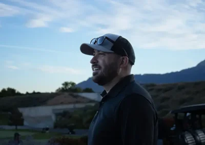 Man with hat and sunglasses looking toward the golf course.