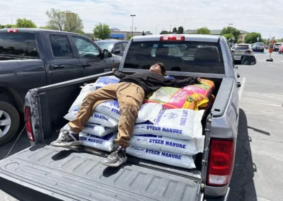 Bob loading bags of soil into the back of a truck.