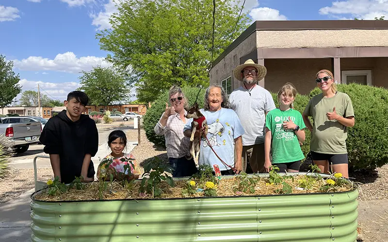 Residents of Summit Garden standing next to garden bed with sprouts